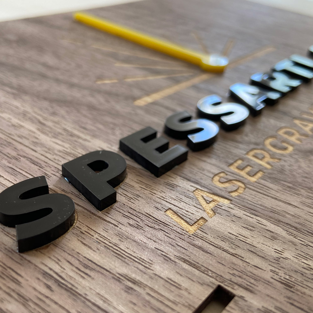 Lasergeschnittene Acrylbuchstaben auf lasergravierter Funierplatte